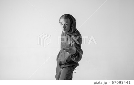 A man hip hop dancer or bboy freezes in one pose on a white background. Bboy doing stylish stunts. 67095441