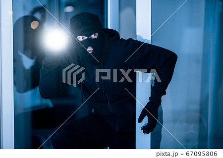 Thief breaking into apartment to steal, using torch 67095806