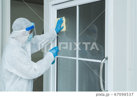 Staff is spraying disinfectant and wiping clean 67098537