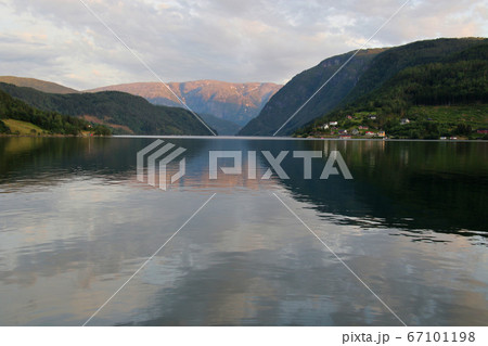 ノルウェー　ハダンゲルフィヨルド、ウルヴィク地区ホテルより南側の黄昏時ののどかな水面を望む 67101198