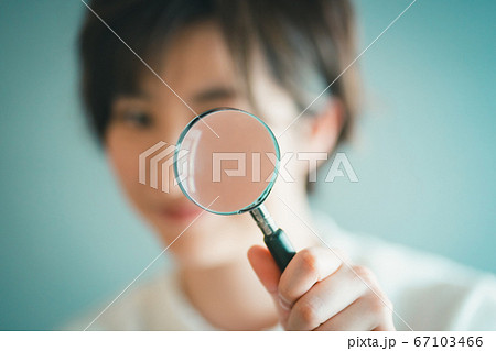 虫眼鏡を持つ30代女性の手元 67103466