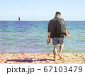 A Man enjoy walking on the sand with bare feet in summer on Brighton Beach in Melbourne, Victoria 67103479