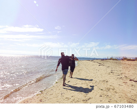 Love couple walking together on the sand under sunlight Love couple walking together on the sand under sunlight 67103480