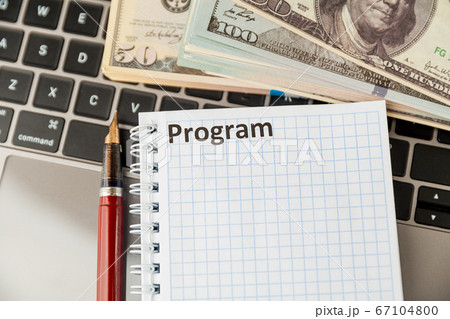 Notepad with word program and money on the laptop. Notepad with word program and money on the laptop. 67104800