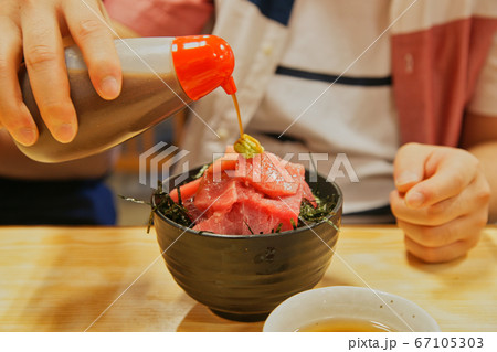 マグロ丼にタレをかけるシーン 67105303