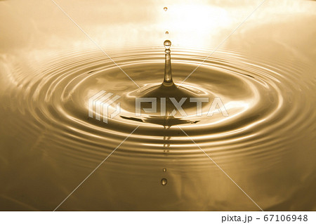 Drops of water on the surface of the water spreading and forming waves 67106948