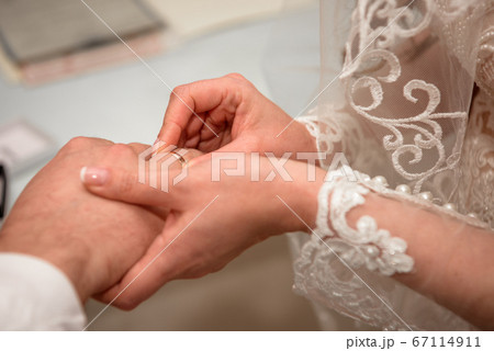 Hands of the newlyweds at the wedding ceremony of dressing the wedding rings. Hands of the newlyweds at the wedding ceremony of dressing the wedding rings. 67114911