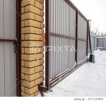 Retractable gate on the fence in winter 67125904
