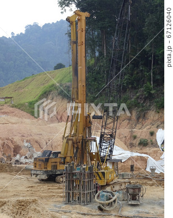 KUALA LUMPUR, MALAYSIA -MARCH 29, 2010: Bore pile rig machine at the construction site. The machine used to driven pile for building foundation work. Operated by skilled workers. KUALA LUMPUR, MALAYSIA -MARCH 29, 2010: Bore pile rig machine at the construction site. The machine used to driven pile for building foundation work. Operated by skilled workers. 67126040