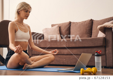 Sporty young lady practicing yoga at home Sporty young lady practicing yoga at home 67128153