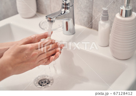 Female washing her hands in the bathroom Female washing her hands in the bathroom 67128412