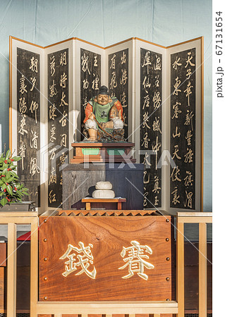 [東京・谷中] 東京の谷中七福神の青雲禅寺に初詣の際に鏡餅の前に露出される恵比寿様の彫刻と賽銭箱。 67131654