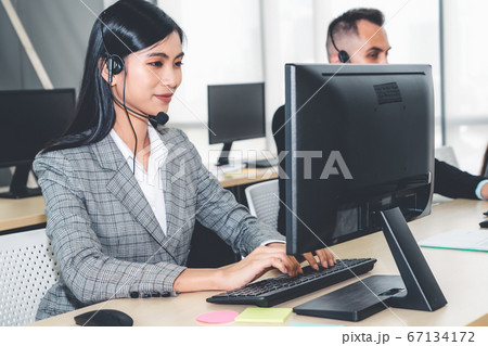 Business people wearing headset working in office Business people wearing headset working in office 67134172