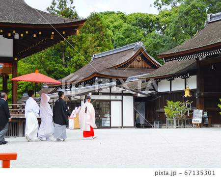 下鴨神社で 巫女さんに連れられて結婚式の写真素材