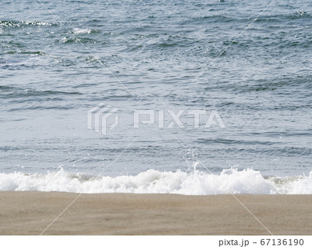 穏やかに小さな波が打ち寄せる砂浜の写真素材