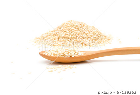 White sesame seeds in wooden scoop on white background White sesame seeds in wooden scoop on white background 67139262