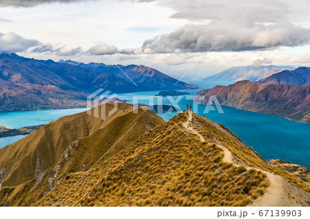 New Zealand hiking people on mountain top Roys Peak enjoying active outdoor lifestyle arms raised cheering happy in New Zealand nature landscape, near Wanaka, Otago, South Island, New Zealand 67139903