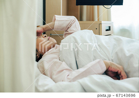 入院先のベッドに横たわる女性［病院］ 67143696