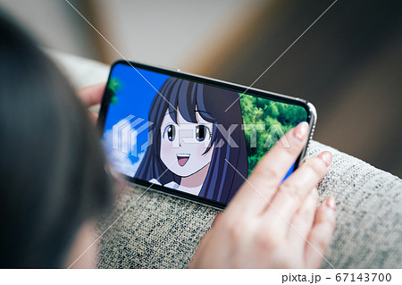 スマホでアニメをみる女性 イメージ の写真素材