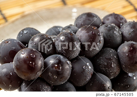 水滴のついた巨峰のアップ。背景すだれで夏イメージ。 水滴のついた巨峰のアップ。背景すだれで夏イメージ。 67145505