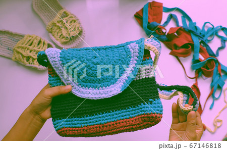 Close up from top view woman hand hold colorful handmade bag from recycle old t shirt Close up from top view woman hand hold colorful handmade bag from recycle old t shirt 67146818