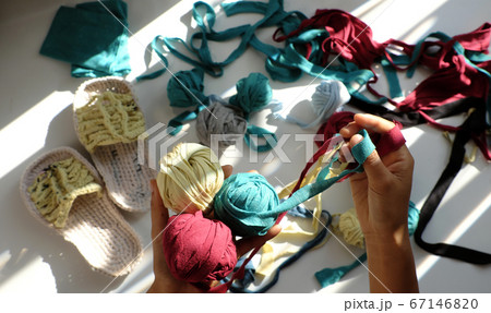 Close up from top view woman hand hold group colorful ball of yarn from recycle old t shirt Close up from top view woman hand hold group colorful ball of yarn from recycle old t shirt 67146820