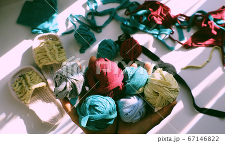 Close up from top view woman hand hold group colorful ball of yarn from recycle old t shirt 67146822