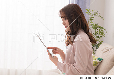 タブレットで動画を楽しむ若い女性 タブレットで動画を楽しむ若い女性 67148439