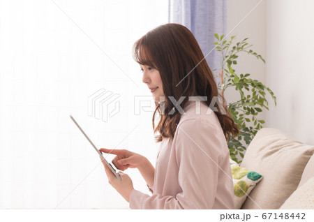 タブレットで動画を楽しむ若い女性 タブレットで動画を楽しむ若い女性 67148442