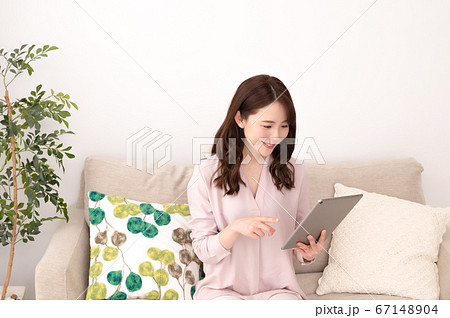 タブレットで動画を楽しむ若い女性 タブレットで動画を楽しむ若い女性 67148904