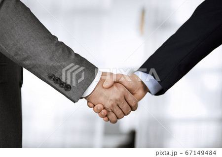 Business people in office suits standing and shaking hands, close-up. Business communication concept. Handshake and marketing Business people in office suits standing and shaking hands, close-up. Business communication concept. Handshake and marketing 67149484