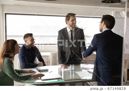 Happy business partners shake hands at meeting in office 67149829