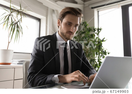 Focused Caucasian businessman work on computer in office Focused Caucasian businessman work on computer in office 67149903