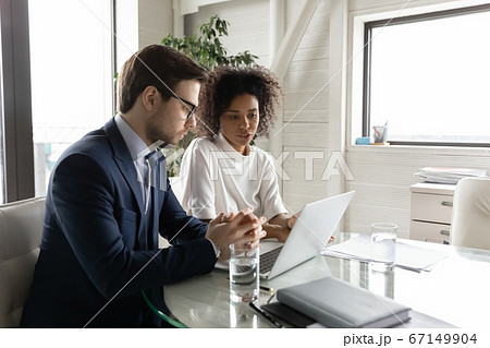 Multiethnic diverse colleagues brainstorm using laptop at briefing Multiethnic diverse colleagues brainstorm using laptop at briefing 67149904