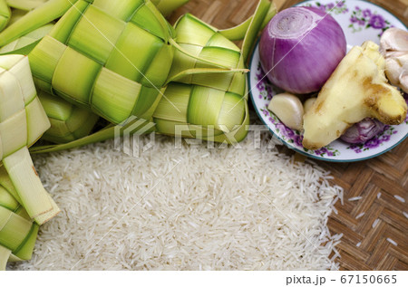 ketupat casing and rice in bamboo container. 67150665