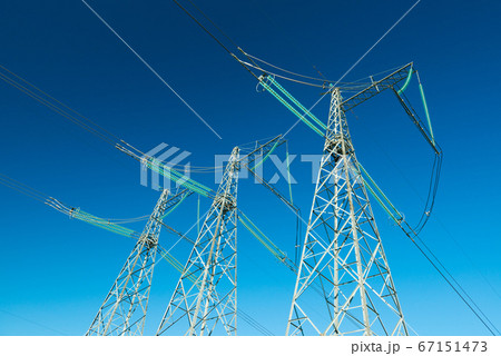 High voltage power lines with blue sky on the background, three electricity pylons High voltage power lines with blue sky on the background, three electricity pylons 67151473