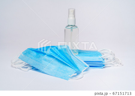 bottle of lotion, sanitizer or liquid soap and protective mask over light grey background 67151713