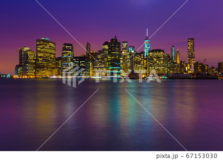 Manhattan skyline at night with colored reflections in water, New York, USA 67153030