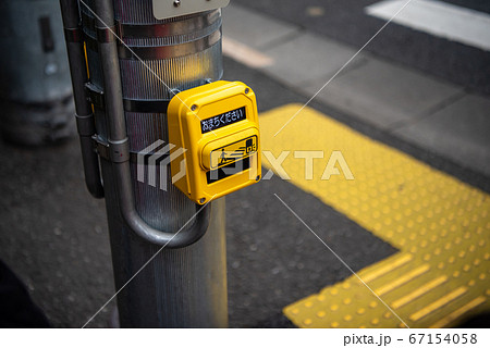 タッチ式の押しボタン新型信号と点字ブロックの写真素材 [67154058