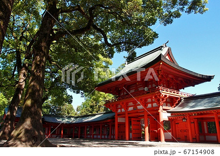 Omiya, Saitama, Japan - May 2, 2017: Omiya Hikawa Shrine on a sunny day. The gorgeous red gate and huge trees looks powerful. Omiya, Saitama, Japan - May 2, 2017: Omiya Hikawa Shrine on a sunny day. The gorgeous red gate and huge trees looks powerful. 67154908