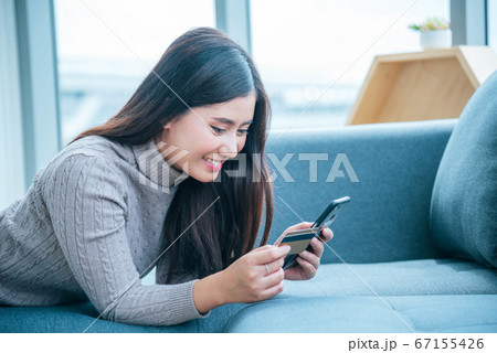 Asian woman using smartphone reading online social 67155426