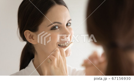 Close up mirror reflection woman with healthy smile cleansing teeth 67156930