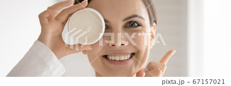 Close up smiling woman holding cream jar, enjoying skincare routine Close up smiling woman holding cream jar, enjoying skincare routine 67157021