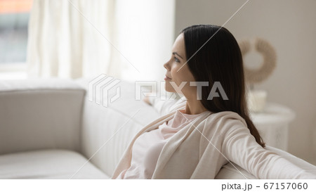 Dreamy satisfied young beautiful woman relaxing on cozy couch 67157060