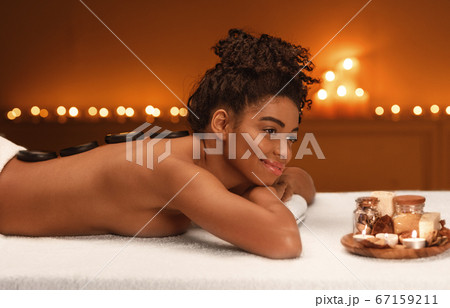 Peaceful african woman enjoying healing massage at spa Peaceful african woman enjoying healing massage at spa 67159211