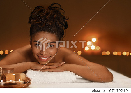 Portrait of cheerful african woman enjoying spa 67159219
