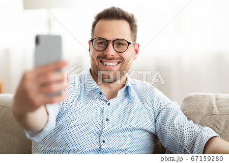 Happy man using smart phone for video call or selfie Happy man using smart phone for video call or selfie 67159280