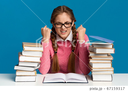 Heavy study, many tasks and lessons. Tense teenager girl in glasses with stacks of books 67159317
