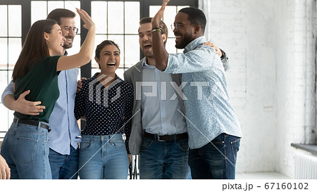 Multiethnic employees accomplish project celebrating success giving high five 67160102