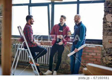 Group of young architects or house designers having coffee and discussing ideas Group of young architects or house designers having coffee and discussing ideas 67160481